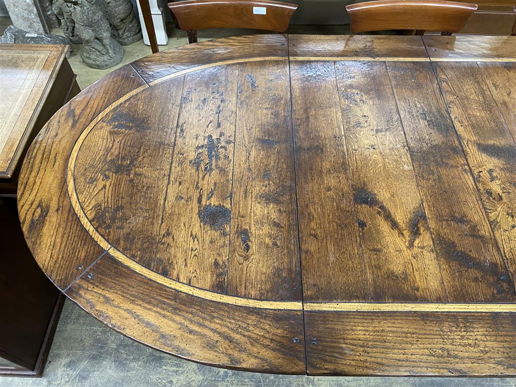 An 18th century style cross banded oak D end twin pillar extending dining table, 284cm extended, two spare leaves, width 130cm, height